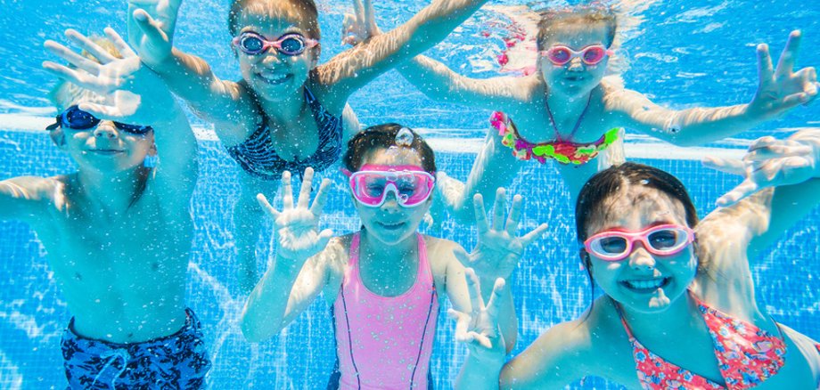 little kids swimming  in pool  underwater.