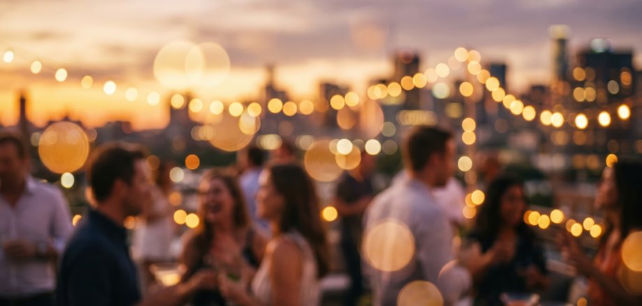 Blurred rooftop party sunset bokeh city skyline background social gathering celebration nightlife evening drinks people outdoor event atmosphere