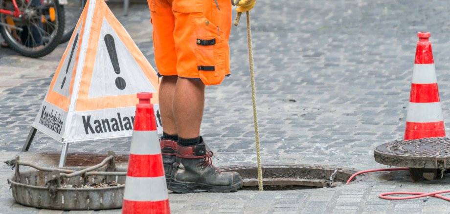 Straßenarbeiter bei Kanalarbeiten Straßenarbeiter bei Kanalarbeiten