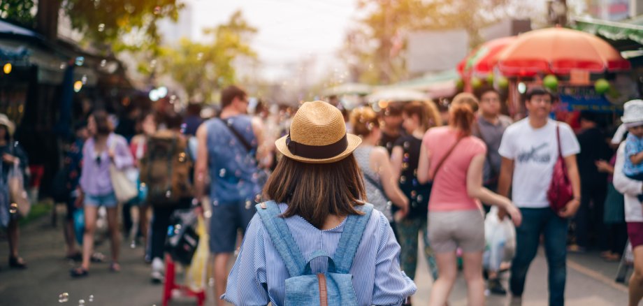 Young woman traveler with sky blue backpack and hat looking the