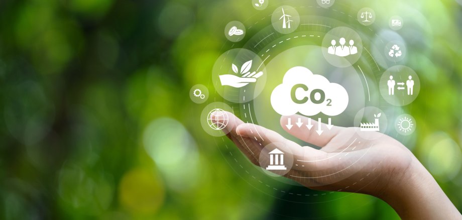 CO2 emission reduction concept in hand with environmental icons, global warming, sustainable development, connectivity and renewable energy green business background.